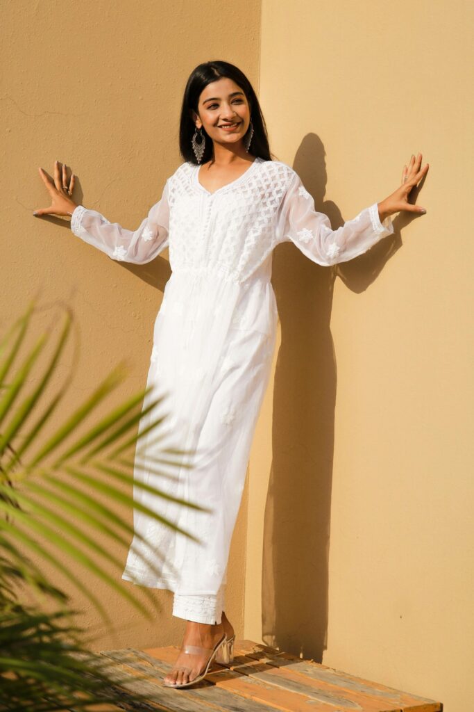 Stylish woman in a white chikankari kurti outdoors, showcasing ethnic elegance and reflecting trendy women’s wear in Kochi.